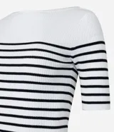 Blusa de punto con textura acanalada, escote barco y mangas 3/4. Diseño a rayas horizontales blancas y negras.