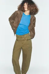 Jeans cargo de tiro medio color verde militar, con pernera recta. Presenta bolsillos laterales de plastrón con cierre de cremallera y cierre frontal con cremallera y botón.