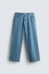 Pantalón de jean azul con rayas verticales texturadas, corte relaxed fit, cinco bolsillos, efecto lavado y cierre frontal con cremallera y botón.