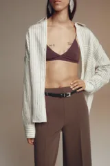Pantalón culotte color verde oliva, de tiro medio y pierna ancha. Incluye cinturón ajustable con hebilla metálica y cierre lateral con cremallera oculta.