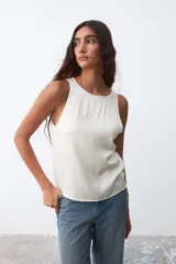 Musculosa color crudo de satén, con cuello redondo y sisas amplias.