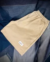 Short de pana color crema con cintura elástica ajustable con cordón y etiqueta con logo de la marca en el ruedo.