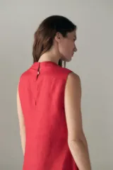 Vestido midi rojo de lino, sin mangas, con escote en V y falda asimétrica al bies.