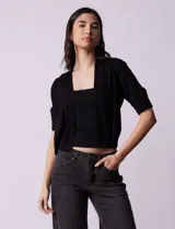 Bolero tejido color beige, marca Ninety, de manga corta con apliques de botones en los puños.