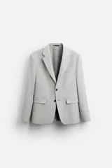 Blazer straight fit color gris claro confeccionado en tejido con viscosa. Tiene cuello con solapas de muesca, manga larga acabada en puño con botón, bolsillo de vivo en pecho, bolsillos de plastrón en cadera y bajo con aberturas en espalda. Cierre frontal de botonadura.