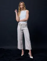 Pantalón capri de lino color beige con estampado floral, marca Zac & Rachel. Tiene pretina con pasadores, cierre y botón. Incluye cinturón de cordones con hebilla metálica. Presenta bolsillos delanteros con botones y bolsillos traseros.