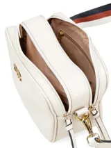 Cartera bandolera de cuero sintético color blanco con logo dorado en el frente. Tiene correa ancha de tela estampada con motivos geométricos y herrajes dorados. Incluye un dije de flecos de cuero en el lateral.