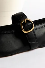 Ballerinas negras de cuero con tira sobre el empeine y hebilla dorada.