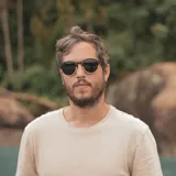 Lentes de sol con montura redonda de madera con detalles en marrón oscuro y claro.