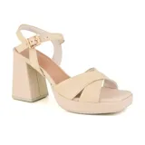 Sandalias de cuero color beige con plataforma y taco cuadrado. Presentan tiras cruzadas en el empeine y pulsera con hebilla al tobillo.