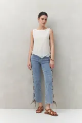 Top sin mangas color blanco, confeccionado en tejido liviano con textura sutil y líneas verticales.