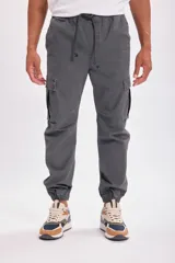 Pantalón cargo jogger gris oscuro con bolsillos laterales y tobillos ajustados.