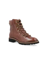 Borcego alpino color verde oliva de cuero napa con detalles metálicos, base de goma estilo trucker con pespuntes naturales en contraste y cordones de algodón al tono. Diseñado en Uruguay y fabricado en Brasil.
