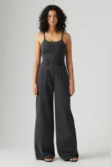 Mono largo de denim negro con corte bustier, tirantes finos y cierre frontal con cremallera.