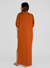 Vestido largo color beige, con escote en V, mangas 3/4 abullonadas y botones frontales.