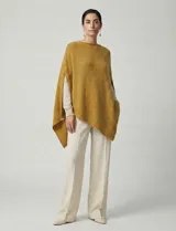 Poncho tejido de punto grueso, color mostaza/mostaza oscuro, con cuello redondo y caída amplia.