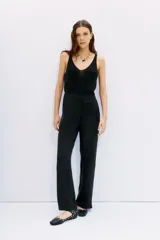 Pantalón palazzo negro de tiro alto confeccionado en cupro y viscosa, con bolsillos diagonales laterales, bolsillos ojal falsos en la espalda y cierre lateral invisible.