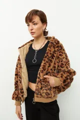 Campera de peluche color crema con capucha y forro de corderito. Tiene cierre frontal, puños y ruedo acanalados.