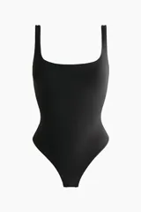 Body negro de microfibra con breteles finos, copas forradas con relleno extraíble, corte alto atrás y refuerzo interior con botones a presión ocultos.