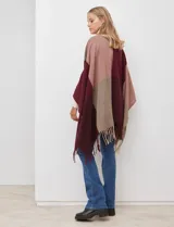 Ruana tejida con diseño colorblock en tonos borgoña, rosa viejo y beige. Presenta flecos en los bordes.