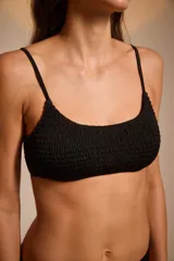 Top de bikini negro con textura arrugada y tirantes finos.