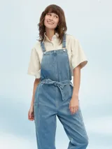 Mono largo de denim celeste con breteles regulables y lazo en la cintura.