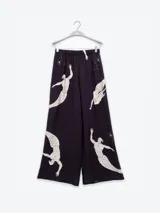 Pantalón palazzo color beige con estampado de girasoles marrones en el ruedo.