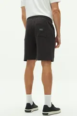 Short de felpa azul marino con textura, bolsillos laterales y trasero, cintura regulable y logo bordado.