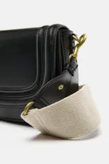 Bolso bandolera color marrón con solapa y correa ancha de tela color crudo.