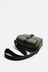 Bandolera negra de acabado engomado, con compartimento principal con cierre de cremallera y bolsillo interior con cremallera. Bolsillo frontal con cierre de hebilla de liberación rápida. Asa de hombro ajustable y extraíble.