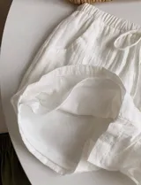 Short blanco de tela rústica con cintura elástica y cordón ajustable.