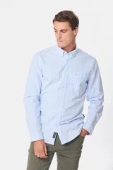 Camisa celeste a rayas verticales blancas, de tela Oxford, con cuello abotonado y manga larga.