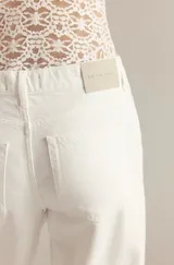 Jean blanco de corte recto y tiro alto, con bolsillos laterales y traseros.