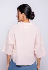 Camisa corta de algodón color rosado, con botones nacarados y dos bolsillos amplios.