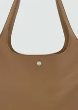 Bolso tipo tote color marrón claro, con doble asa de hombro y cierre metálico a presión.