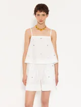 Top blanco de poplin con breteles finitos y piedras al tono en delantero y espalda. Breteles, escote y aberturas laterales terminadas con satén al tono. Cierre invisible lateral.