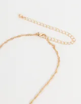 Cadena corta dorada con dije de la letra A cubierto de strass.