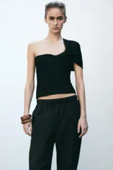 Pantalón tobillero negro con cintura elástica ajustable con cordones, bolsillos delanteros y falsos bolsillos con solapa en la espalda.