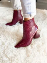 Botas cortas color marrón con estampado de cocodrilo, punta fina y taco de 8.5 cm.