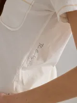 Remera color crudo de algodón, con bolsillo en el pecho y bordes con costuras a la vista.