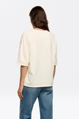 Remera color crema de corte recto, cuello redondo y manga corta. Estampado frontal con dos leopardos y el logo de la marca en marrón.