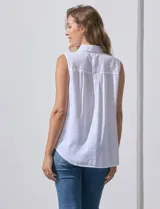 Camisa blanca sin mangas, de lino, con cuello clásico, escote en V, cierre frontal con botones y bolsillo en el pecho.