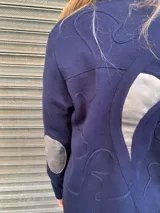 Cardigan azul marino tejido en algodón con detalles de cintas tejidas y cuero.