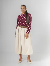 Falda midi de corderoy color beige claro, con pliegues verticales marcados y cintura elastizada. Incluye un cinturón desmontable de cuero marrón con hebilla dorada.