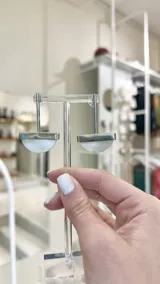Aros colgantes con forma de semicírculo, hechos en alpaca color plateado y guampa natural color blanco.