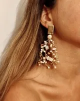 Aros colgantes con base dorada y diseño con cuentas de diferentes tamaños en tonos beige, marrón y dorado.