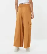 Pantalón pantalona color marrón, de lino y viscosa, con cintura elástica, bolsillos laterales y corte amplio.
