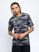 Remera de entrenamiento Umbro color gris con estampado geométrico en tonos grises y negros. Logo de la marca en el pecho.