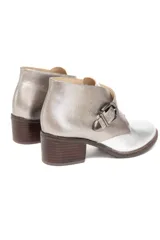 Botín plateado de cuero con efecto metalizado, corte lateral en forma de V y ajuste con hebilla. Tiene taco de madera bajo.