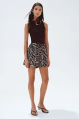 Short marrón con estampado de hojas blancas, cintura elástica con cordón ajustable y bolsillos laterales.